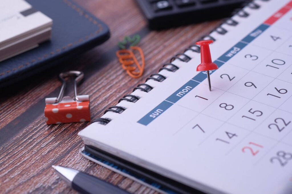 pexels-photo-11333728 Desk elements like calendar and pins for effective planning.
