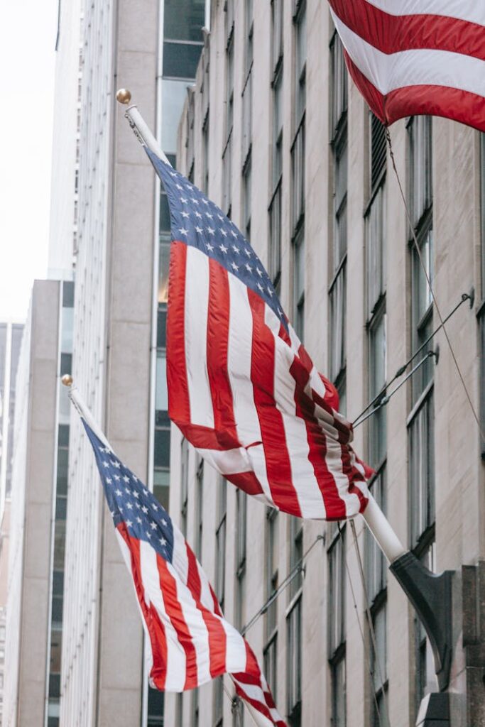 pexels-photo-7078022 Row of American flags with stripe and star ornament on wall of embassy building in town